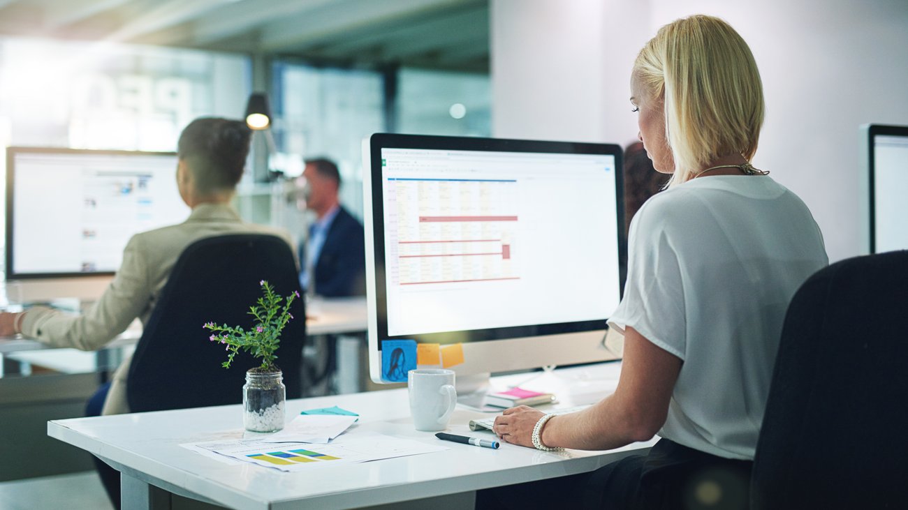 Generische Officeszene: Frau sitzt vor Bildschirm